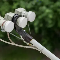 Trzy konwertery LNB na uchwycie anteny satelitarnej, gotowe do odbioru sygnału z satelity Hotbird.