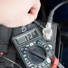Pomiar napięcia akumulatora multimetrem, wskazanie 12.6V. Może to być etap diagnostyki przed odsiarczanie akumulatora.