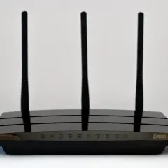 Czarny router Wi-Fi z trzema antenami, model N600. Wskaźniki LED na froncie pokazują status połączenia.