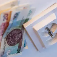Pieniądze obok gniazdka elektrycznego. Zastanawiasz się, jak sprawdzić rachunek za prąd PGE?