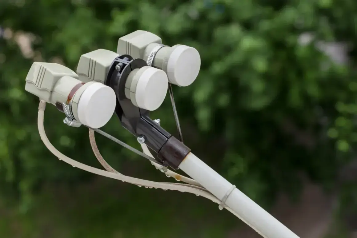 Trzy konwertery LNB na uchwycie anteny satelitarnej, gotowe do odbioru sygnału z satelity Hotbird.