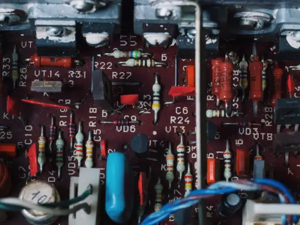 Wnętrze wzmacniacza samochodowego z widocznymi rezystorami, kondensatorami i innymi elementami elektronicznymi. To zdjęcie może pomóc zrozumieć, jak podłączyć wzmacniacz samochodowy.