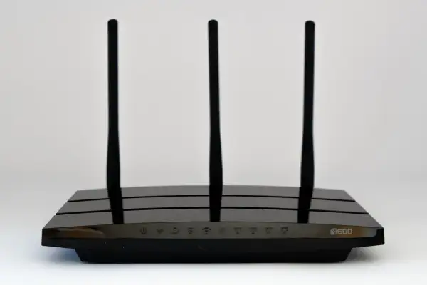 Czarny router Wi-Fi z trzema antenami, model N600. Wskaźniki LED na froncie pokazują status połączenia.