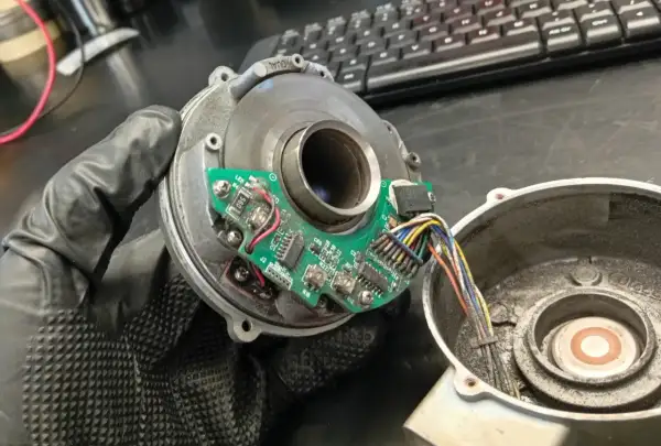 Napęd elektryczny zamiast szarpaka. Widoczny rozrusznik z płytką drukowaną i przewodami, trzymany w rękawiczce.