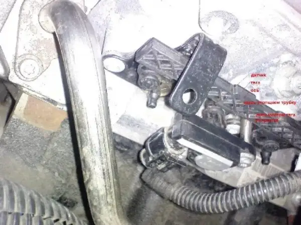 Czujnik w Oplu, powiązany z błędem DTC P1113, zamontowany na metalowej rurze.